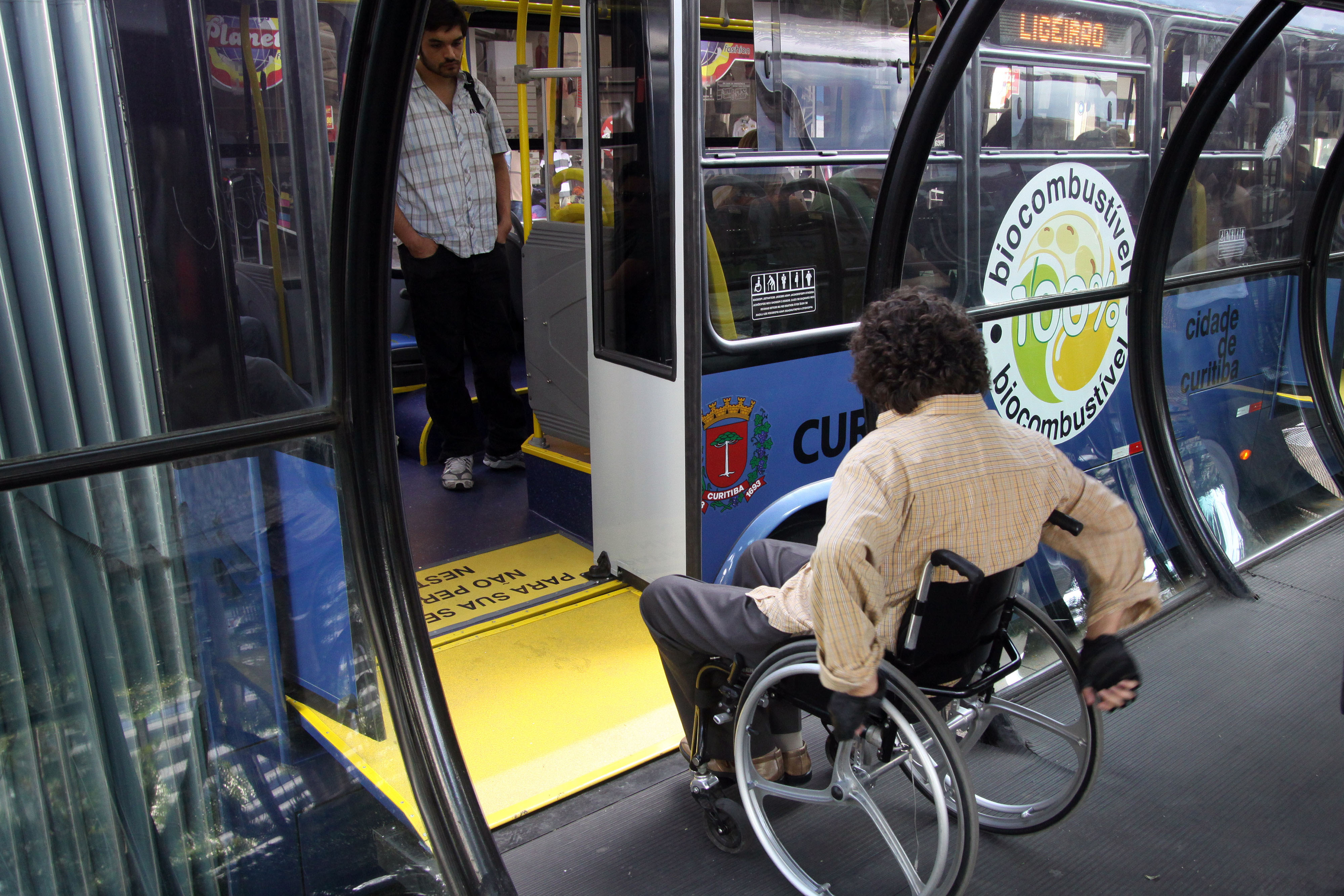 Persona su una sedia a rotelle che entra in autobus a Curitiba.